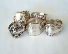 a group of silver rings sitting on top of a white table