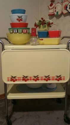 an old fashioned serving cart with bowls on it