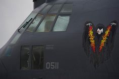 the side of an air force jet with two wings painted on it's face