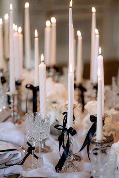 a table topped with lots of white candles