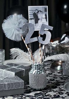 the table is decorated with silver and white decorations for 25th birthdays, as well as gifts