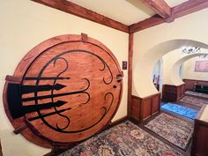 a large wooden clock mounted to the side of a wall next to a doorway and carpet