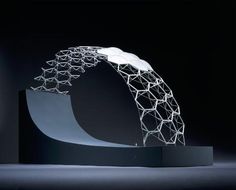 an artistic sculpture is displayed on a black surface with light coming from the top and bottom