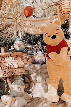 a large teddy bear standing next to a wooden sign