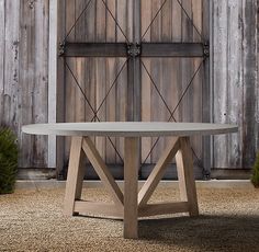 a concrete table sitting in front of a barn door