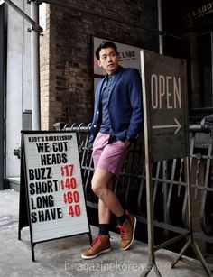 a man standing next to a sign in front of a building