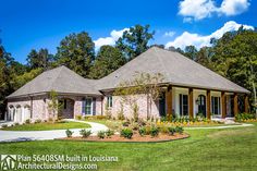 a large brick house in the middle of a lush green yard with lots of trees