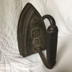 an old iron hook on a bed with the number 66 written on it's side