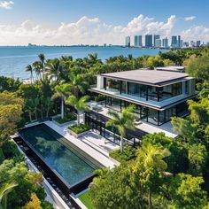 an aerial view of a house with trees and water in the foreground