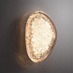 an oval light fixture on the wall in a room with dark walls and flooring