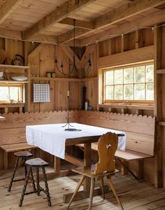 a table and chairs in a room with wooden walls