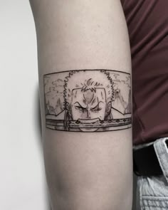 a person with a tattoo on their arm that has an image of two people in the background