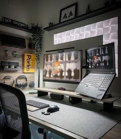 a laptop computer sitting on top of a desk next to a mouse and keyboard in front of a monitor