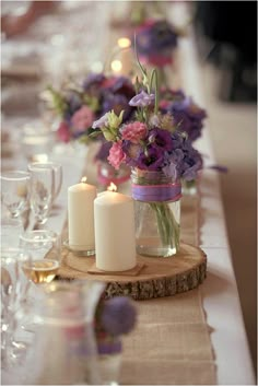 an image of a table setting with candles and flowers in vases on the table