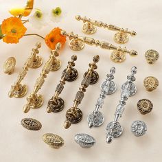 there are many different types of door knobs and pulls on the table with flowers in the background