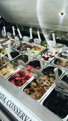 a display case filled with lots of different types of ice creams and toppings