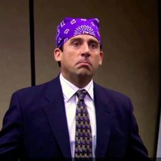 a man in a suit and tie wearing a purple bandana