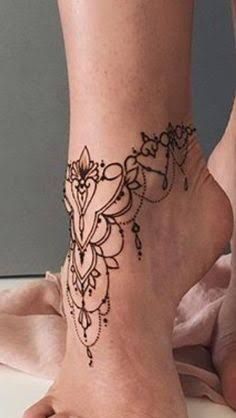 a woman's foot with a henna tattoo on the side of her leg