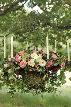 an image of a chandelier with flowers and candles hanging from it's sides