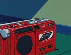 a red radio sitting on top of a green floor next to a blue and white wall