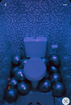 a toilet surrounded by balls in a bathroom