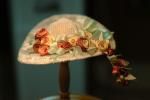 a white hat with flowers on it sitting on top of a table