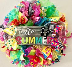 a colorful wreath with the words hello summer written on it and some ribbons around it