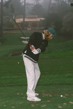 a man swinging a golf club on a foggy day