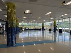 an empty room with blue and gold decorations on the floor, people are standing in the background