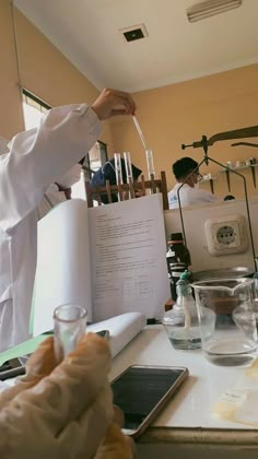 a person in a lab coat is holding up a test tube