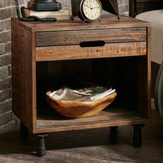 an old wooden table with a clock and telephone on it