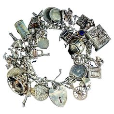 An outstanding vintage sterling silver charm bracelet loaded with silver charms. This bracelet has been built upon over many years and boasts a really impressive and unique array of different charms. It is built upon a chunky silver curb bracelet, the bracelet fastens with a heart shaped padlock fastener and has a fine link safety chain. The Charms all vary in size and age from 60s to the 90s, many marked for silver. There are 30 charms and some really interesting ones, some of our favourite ones include a flying fish, ship in a bottle, rocking chair, policeman's helmet and a lucky horseshoe There is one silver plated charm and a few coin charms too. Marks and era: The padlock is marked silver, bracelet tests as sterling silver, most charms are marked for sterling silver or 800 silver, the Heirloom Style Silver Metal Bracelets, Unique Nickel-free Silver Charm Bracelet, Unique Silver Nickel-free Charm Bracelet, Unique Silver Jewelry With Vintage Charm, Antique Sterling Silver Hallmarked Charms, Antique Sterling Silver Charms For Collectors, Antique Sterling Silver Charms For Collectible, Heirloom Silver Bracelet With Vintage Charm, Antique Sterling Silver Charms In Silver