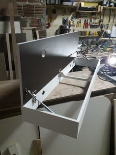 a metal box sitting on top of a table in a room filled with woodworking tools