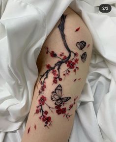 a woman's arm with red flowers and butterflies on it