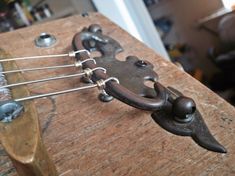 a close up of an old guitar's head and strings on a wooden table