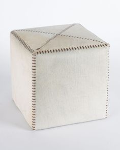 a small white box with stitching on the sides and an opening at the top