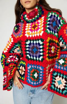 a woman wearing a red sweater with multicolored crochet