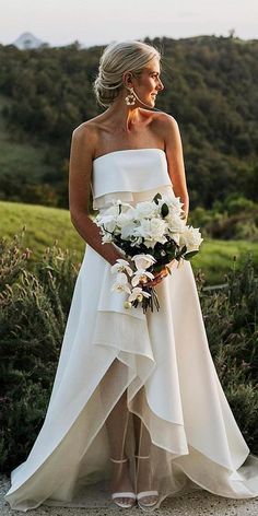 a woman in a wedding dress holding a bouquet