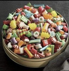 a bowl filled with assorted candy on top of a table