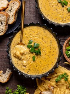 two bowls filled with soup next to some bread