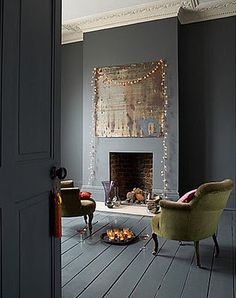 a living room filled with furniture and a fire place in front of a painting on the wall