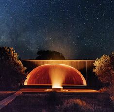 an outdoor fire pit surrounded by trees under the night sky with stars in the background