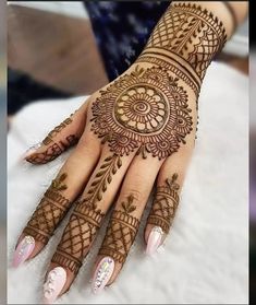 a woman's hand with henna tattoos on it