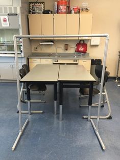 two desks in a room with shelves and cabinets on the wall behind them,