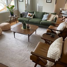 a living room filled with lots of furniture and decor on top of a white rug