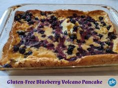 a blueberry and cheesecake in a glass baking dish on a white table with the words gluten - free blueberry volcano pancake