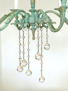 a green chandelier with crystal drops hanging from it