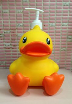 a yellow rubber ducky sitting on top of a counter next to a soap dispenser