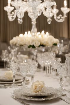 Elegant table setting with crystal glassware, white roses, and a chandelier above. Elegant Dining Table Decor, Dining Table Decoration