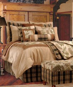 a bedroom with a bed, foot stool and lamp on the side table in front of it